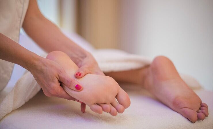 Une personne qui masse les pieds d'une autre