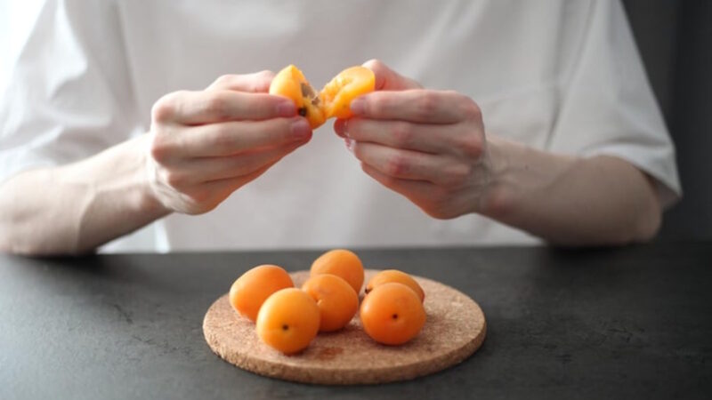 Un homme qui coupe des abricots